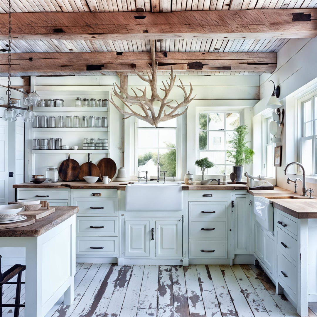 A spacious rustic kitchen bathed in white, featuring vintage wooden panels, a farmhouse sink, marble countertops, and an island with a butcher block top. A vintage refrigerator and an antler chandelier add character to the space.