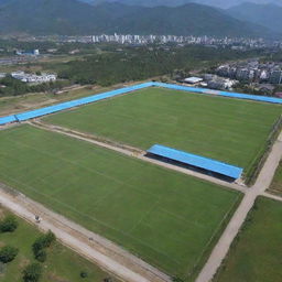 A picturesque view of Dungsam Football Academy; green football fields, students in sporty attire, coaching staff and training sessions in full effect under a clear blue sky.