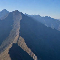 A massive wall stretching across numerous towering mountains under a clear sky.