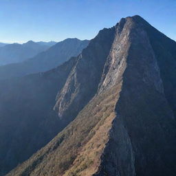 A massive wall stretching across numerous towering mountains under a clear sky.