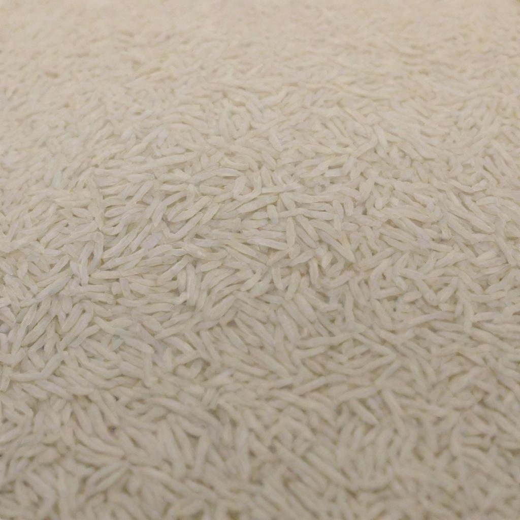 A large quantity of Basmati rice is displayed, highlighting the abundant amount of its long, slender, pearly white grains.