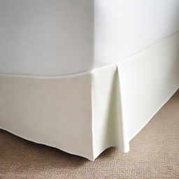 A corner of a bed with a clean bed skirt