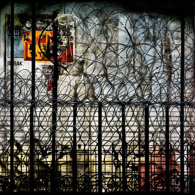 An abstract image of the vintage Communist Iron Curtain, featuring barbed wire, concrete walls, and propaganda posters, using deep colors and stark contrasts to highlight themes of oppression and isolation