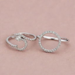 Two silver engagement rings, one with diamonds forming the elegant shape of the letter J, and the other with diamonds beautifully configured into the letter R.