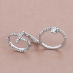 Two silver engagement rings, one with diamonds configured into a distinct shape of the letter 'J', and the other with diamonds arranged in the form of the letter 'R', both of the same elegant design.