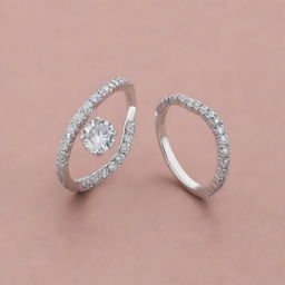 Two silver engagement rings, one with diamonds configured into a distinct shape of the letter 'J', and the other with diamonds arranged in the form of the letter 'R', both of the same elegant design.