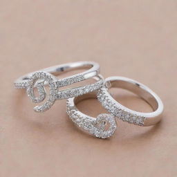 Two matching silver engagement rings encrusted with sparkling diamonds. One ring features an exquisite design of the letter 'J' and the other echoes this design but with the letter 'R'.