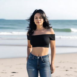 A woman in her 40s with black hair, wearing a black crop top and skinny jeans, standing by the sea