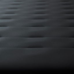 A high-resolution close-up image of the flat texture of black foam mattress material
