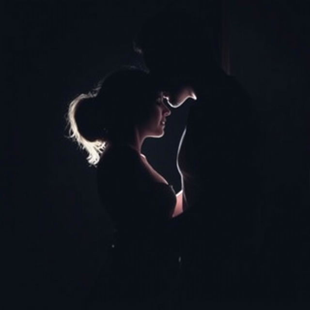 A couple making love in a darkened room, their forms barely visible in the dim light