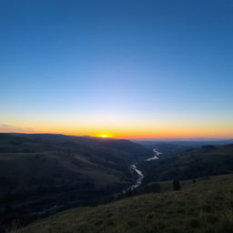 A beautiful landscape with rolling hills, a clear blue sky, and a vibrant sunset