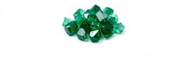 A close-up view of a cluster of emerald crystals resting on a pristine white background