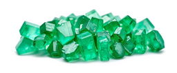 A close-up view of a cluster of emerald crystals resting on a pristine white background