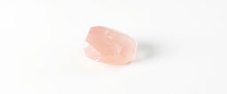 A single piece of rose quartz crystal displayed on a stark white background