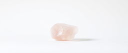 A single piece of rose quartz crystal displayed on a stark white background