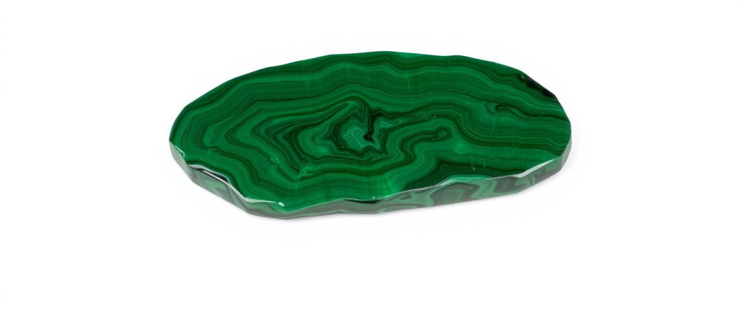 A single piece of malachite resting on a clean white background