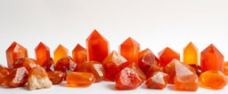 A collection of carnelian crystals displayed against a white background