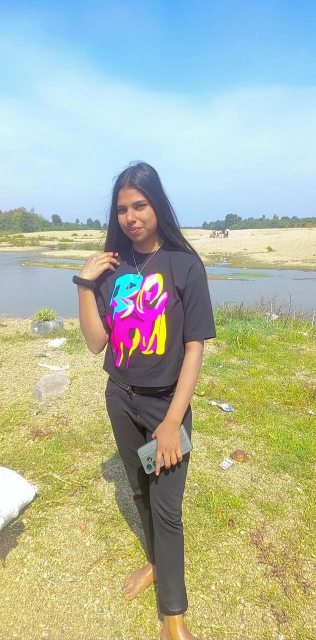 A young person standing outdoors on a sunny day