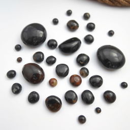 A collection of large and small Apache Tear stones displayed on a pristine white backdrop