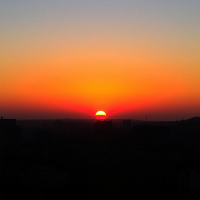 A breathtaking sunset in Lima, with the sun dipping below the horizon and painting the sky in vibrant shades of orange