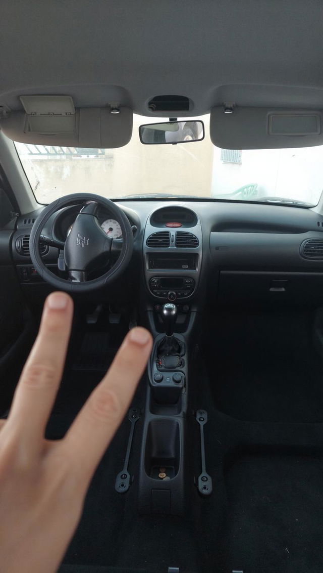 Peugeot 206 interior with a blue color theme, showcasing the dashboard, steering wheel, and seating