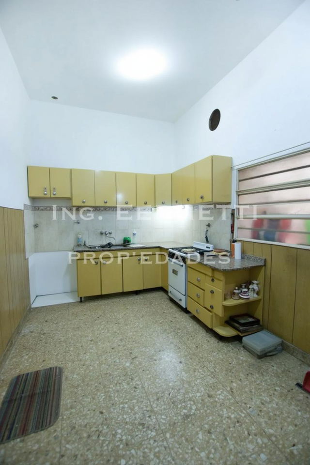 A simple, minimalist kitchen with beige cabinets and a white ceiling