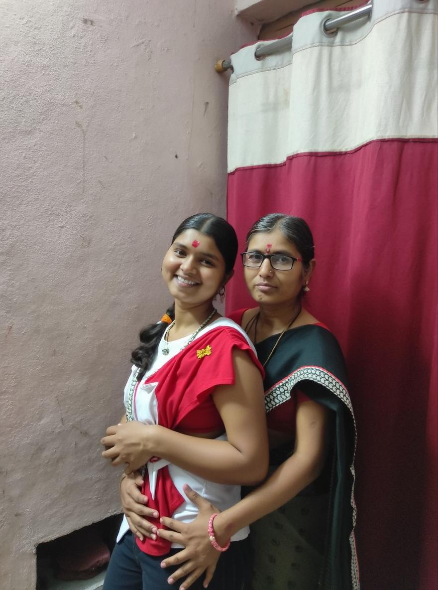 Two women standing together in a warm, casual indoor setting