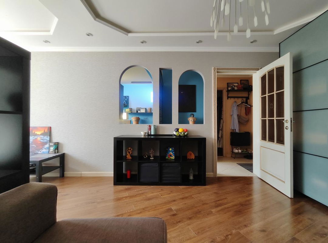 A modern living room featuring blue-toned walls and white furniture