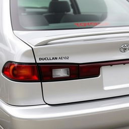 A silver Toyota Corolla AE102, showcasing a subtle yet stylish ducktail spoiler mounted on the trunk