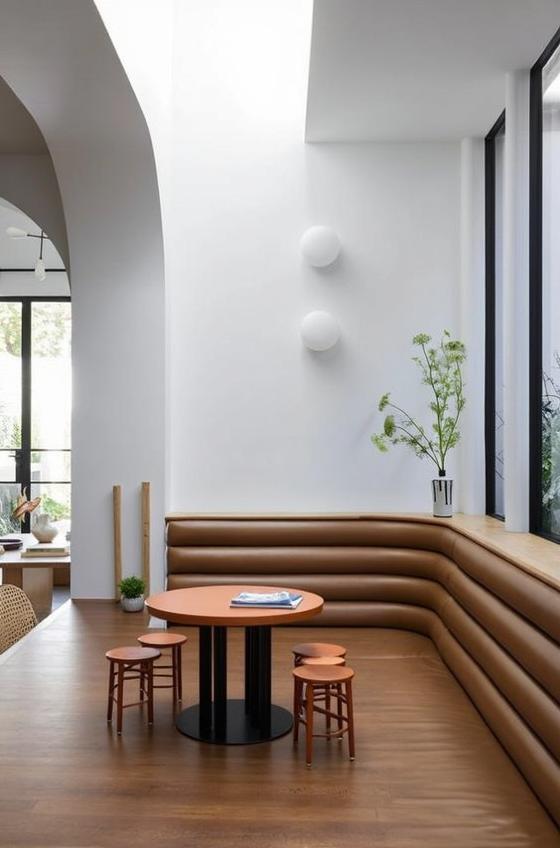 A sleek dinner table setup featuring a modern wooden table with a smooth finish and elegant curved bench seating