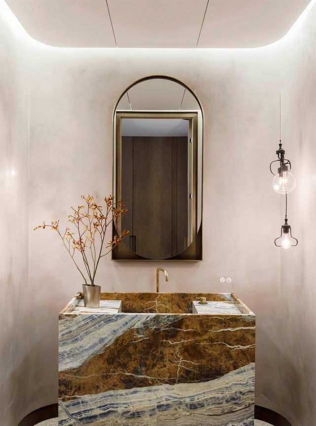 A luxurious bathroom featuring a chic vanity with a stunning marble countertop that has deep blue and gold veining