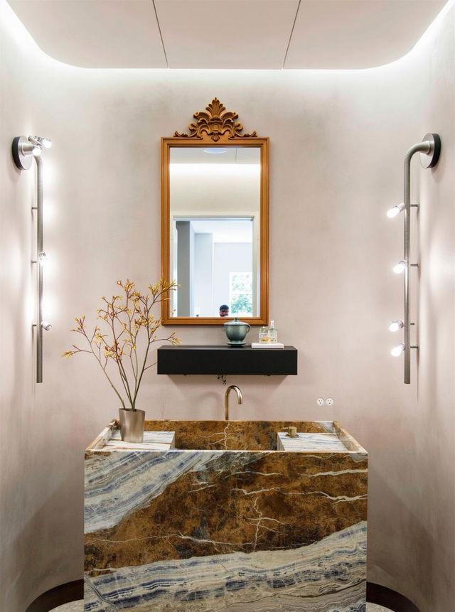 An elegant bathroom with a stylish stone sink featuring deep brown and gold veining