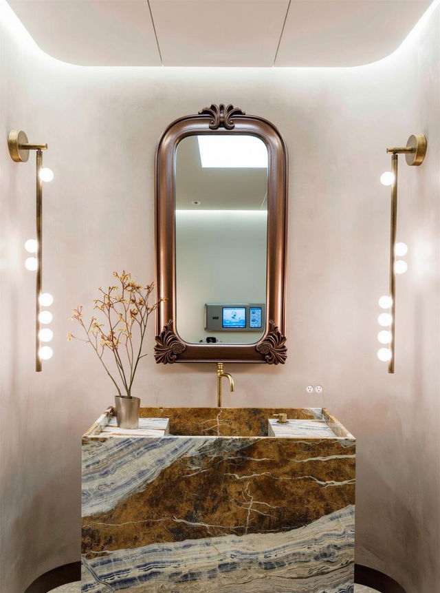 A luxurious bathroom featuring a chic marble vanity with rich blue and gold veining