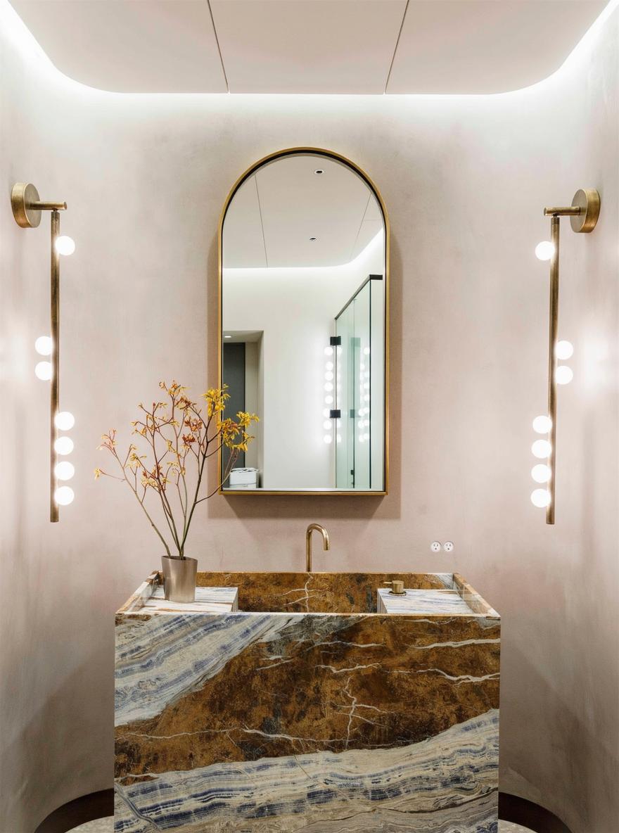 An elegant bathroom showcasing a stunning modern stone sink with intricate gold and deep blue veining