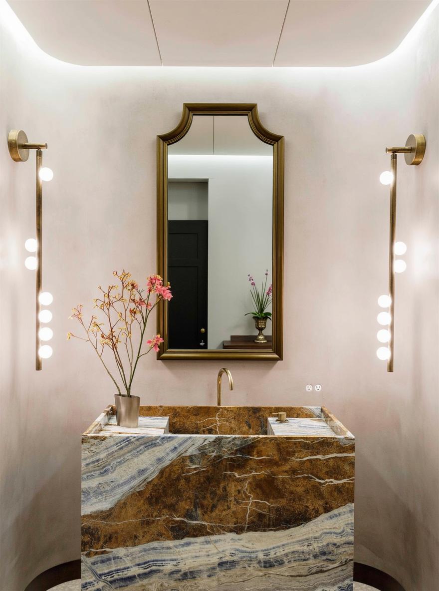 A sleek bathroom featuring a prominent modern stone sink with stunning blue and gold marble patterns