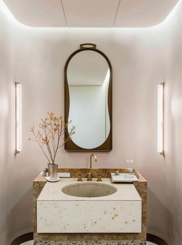 A sophisticated bathroom interior featuring a striking modern stone sink with elegant white and grey veining