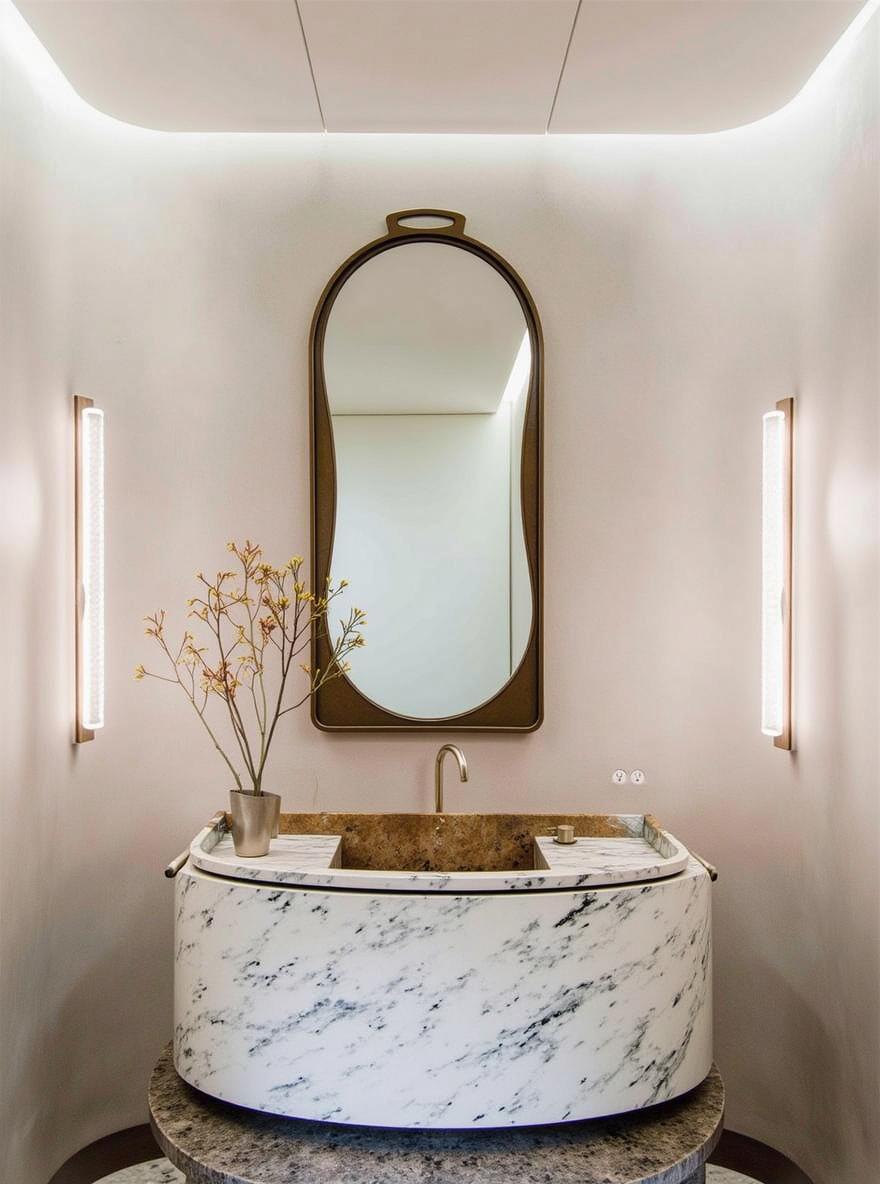 A sophisticated bathroom interior featuring a modern sink crafted from sleek white marble with subtle grey veining