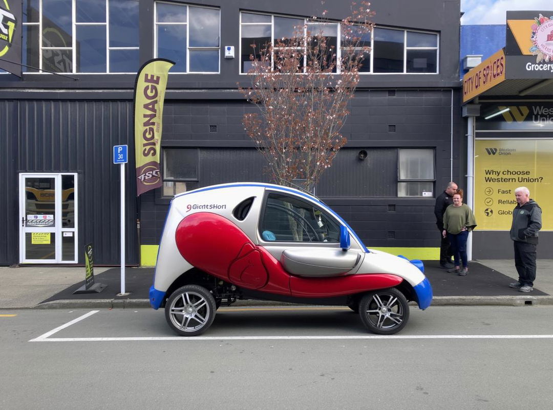 A cool and dynamic livery design for a small electric delivery vehicle, showcasing an eye-catching combination of red and black colors