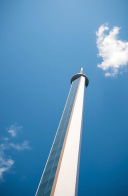 A bright red dot at the peak of a tall tower against a clear blue sky