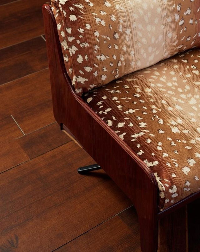 A close-up view of a mid-century modern sofa with plush, patterned upholstery in warm shades of brown and cream