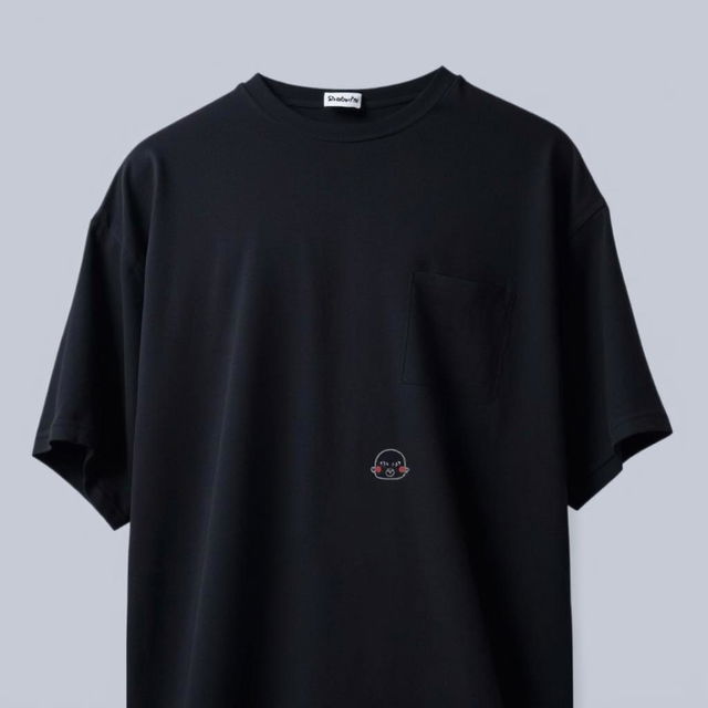 An oversized dark t-shirt featuring a small, cute animated shadow design on the chest area