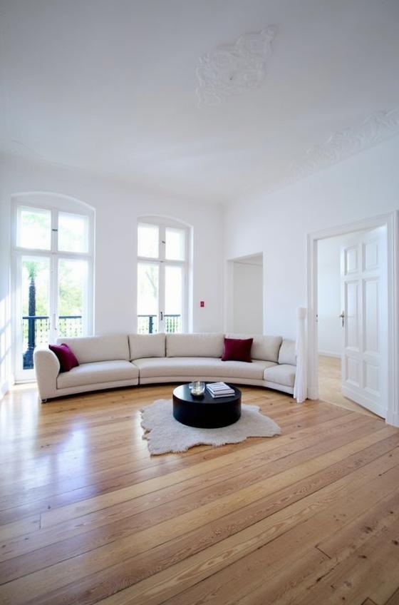 A spacious Scandinavian luxury living room featuring large windows allowing ample natural light to fill the space