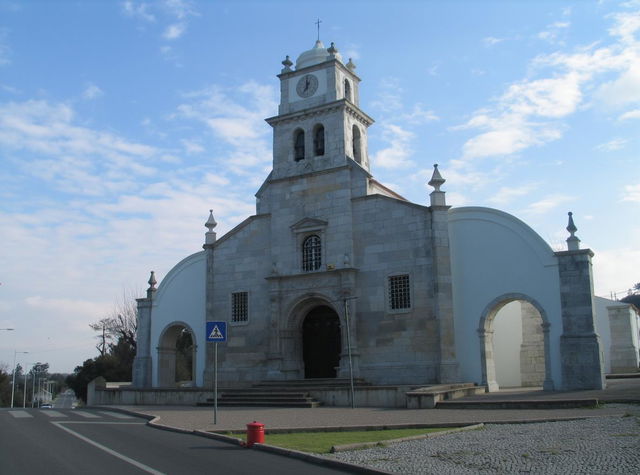 A stunning historical church in Atalaia, Vila Nova da Barquinha, featuring a striking stone facade with detailed carvings and a prominent clock tower