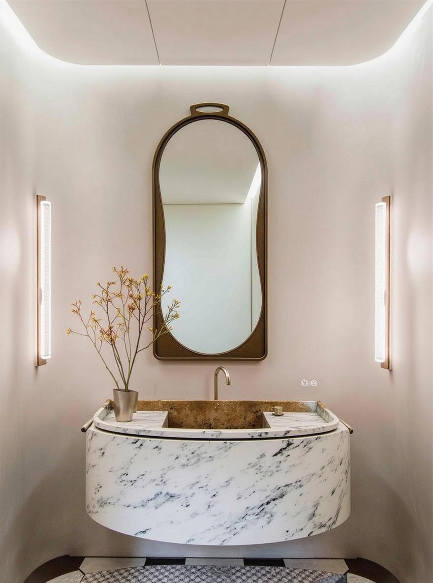 A modern bathroom interior featuring a unique oval-shaped marble vanity