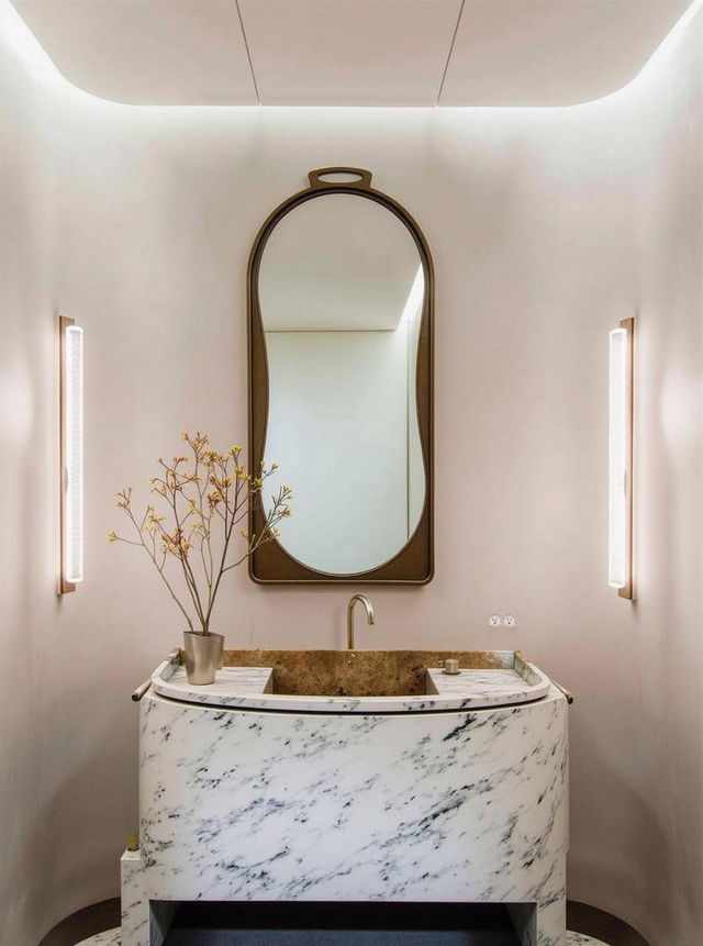 A luxurious modern bathroom featuring a unique oval-shaped marble sink