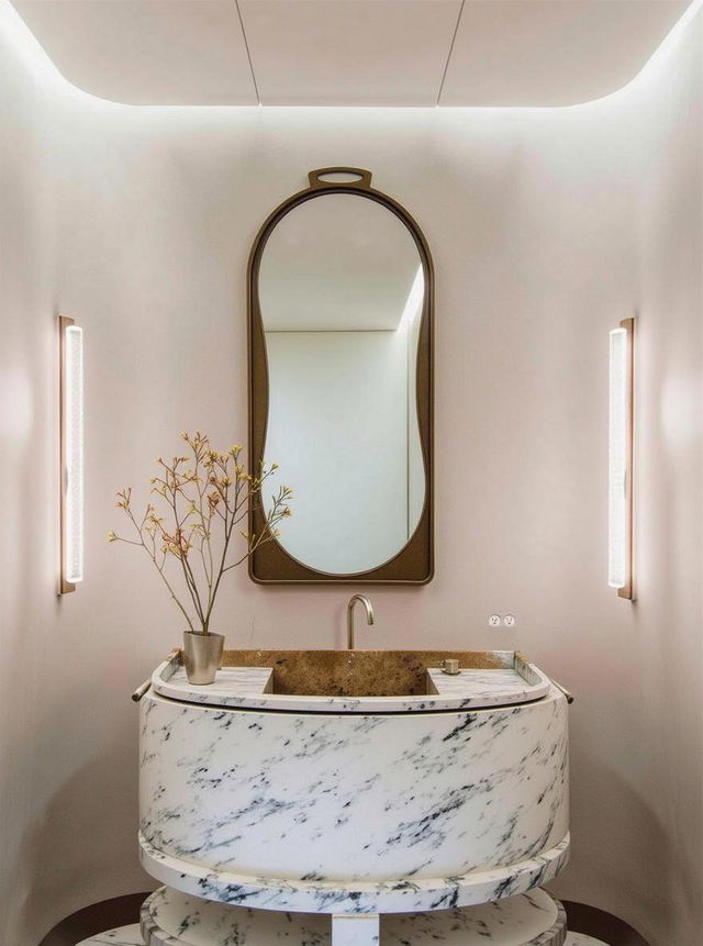 A contemporary bathroom interior featuring a unique oval-shaped marble vanity with subtle veining