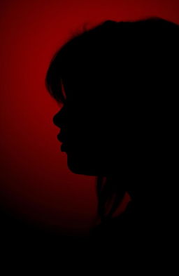 A close-up silhouette profile of a girl gently whispering, with her lips slightly parted