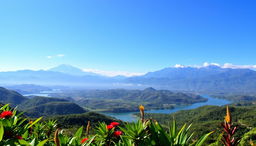 A stunning landscape of Colombia, featuring lush green mountains and rolling hills under a clear blue sky