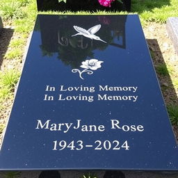 A simple, plain, wide rectangular black granite headstone with a flat top