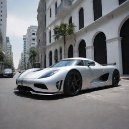 Visualize a sleek, silver Koenigsegg Agera R parked in the bustling urban environment of Malé City. The car contrasts against the traditional architecture of the Maldivian capital, creating a fascinating fusion of modernity and custom.